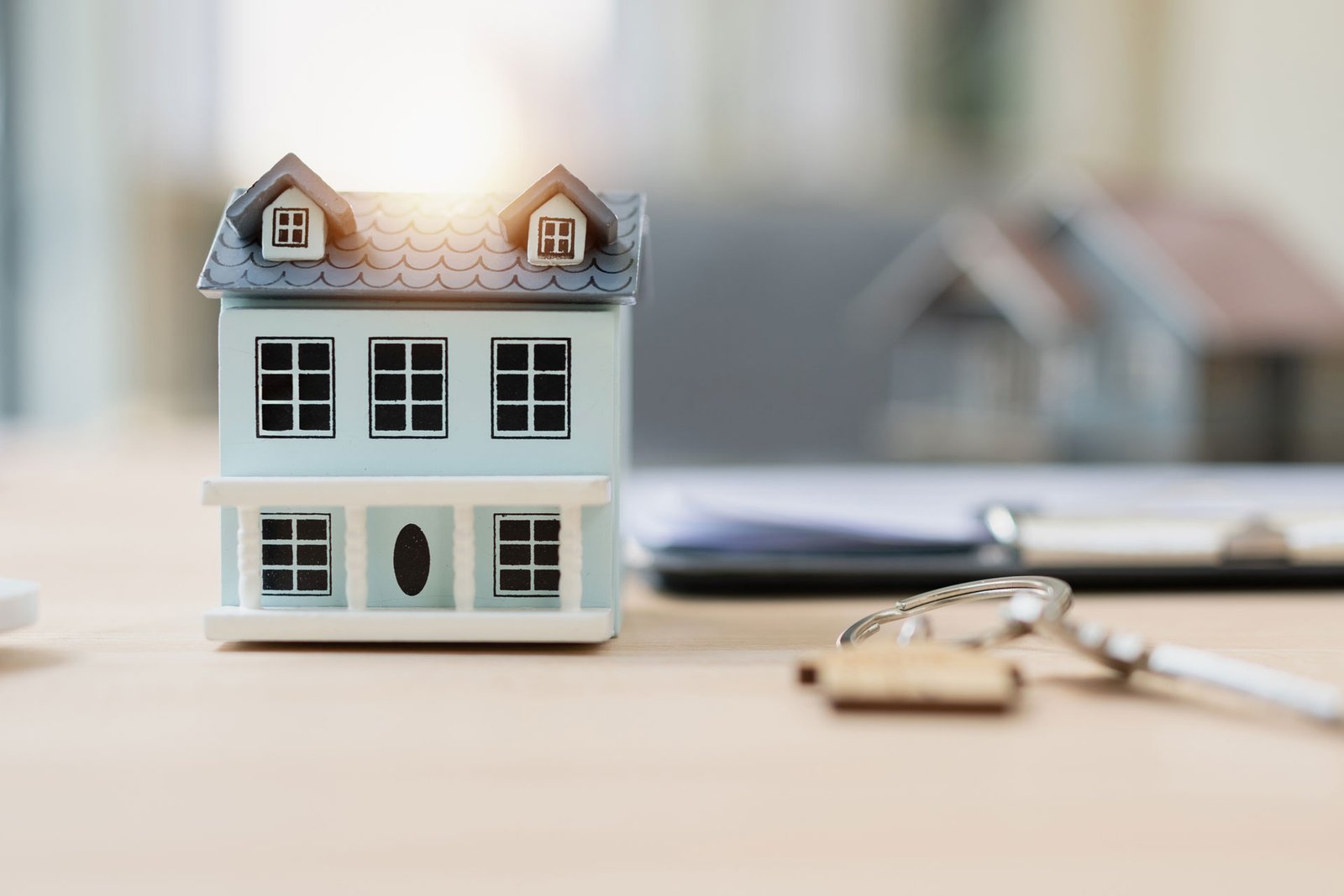 Casa en miniatura y llaves para representar bienes hereditarios